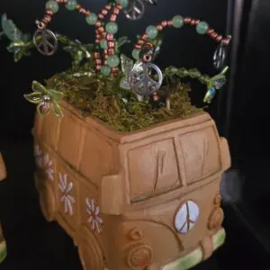 A handcrafted model of the Scooby-Doo Mystery Machine decorated with beads and moss.