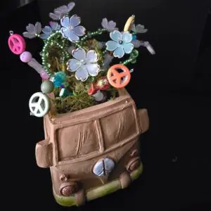 A brown van-shaped planter with colorful flowers and peace signs.