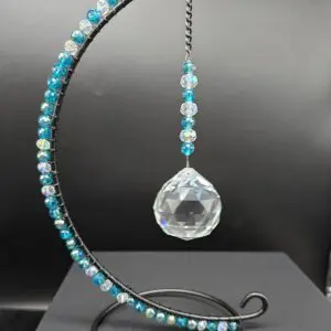 Decorative hanging ornament with blue beads and a crystal ball.