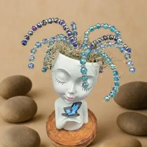 A ceramic bust with colorful glass tentacle-like decorations on its head.