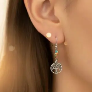 Close-up of a woman's ear wearing a tree of life dangling earring.