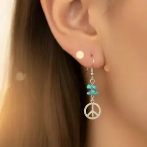 Close-up of a peace sign earring with turquoise beads on a woman's ear.