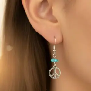 Close-up of a woman's ear with a peace sign earring featuring a turquoise bead.