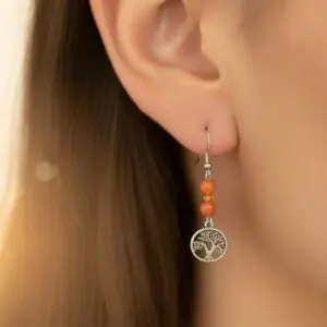 Close-up of an ear with a handmade beaded earring featuring a silver charm.